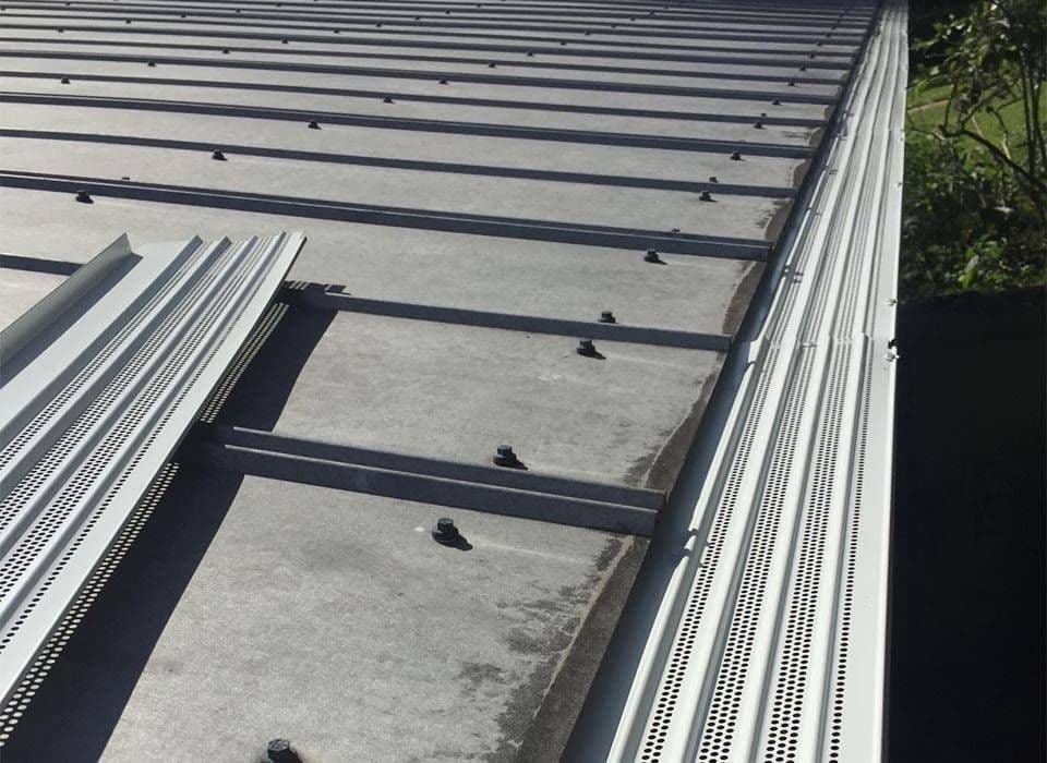 Newly-installed white gutter guards.