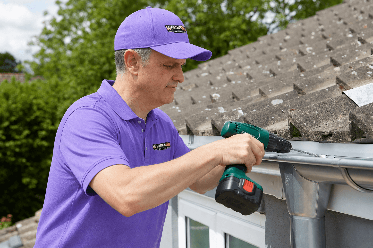 A worker in a hard hat replaces gutters on a house.